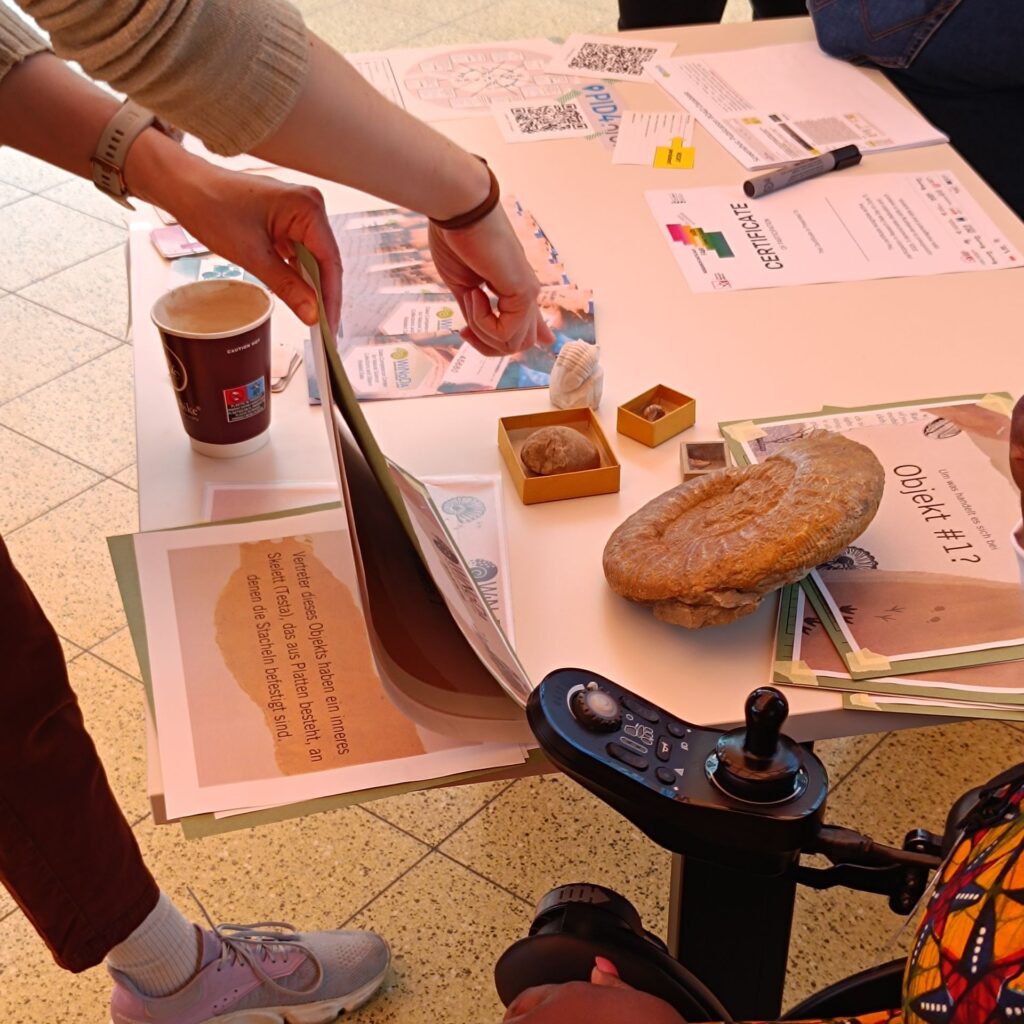 Ein Besucher am WiNoDa-Stand spielt „Data Detectives“. Wir sehen mehrere Mappen mit Hinweisen zur Identifizierung der mysteriösen Objekte und eine Hand, die auf ein Objekt zeigt.