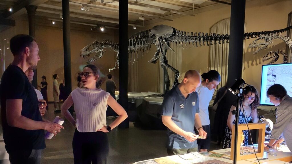 People are talking while a skeletton of the T-Rex Tristan is in the background.