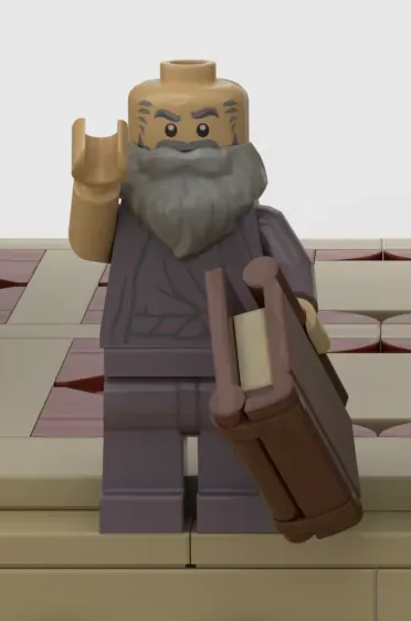 Eine Lego-Figur des Philosophen Plato, mit erhobener rechtem Arm und einem Buch in der linken Hand.